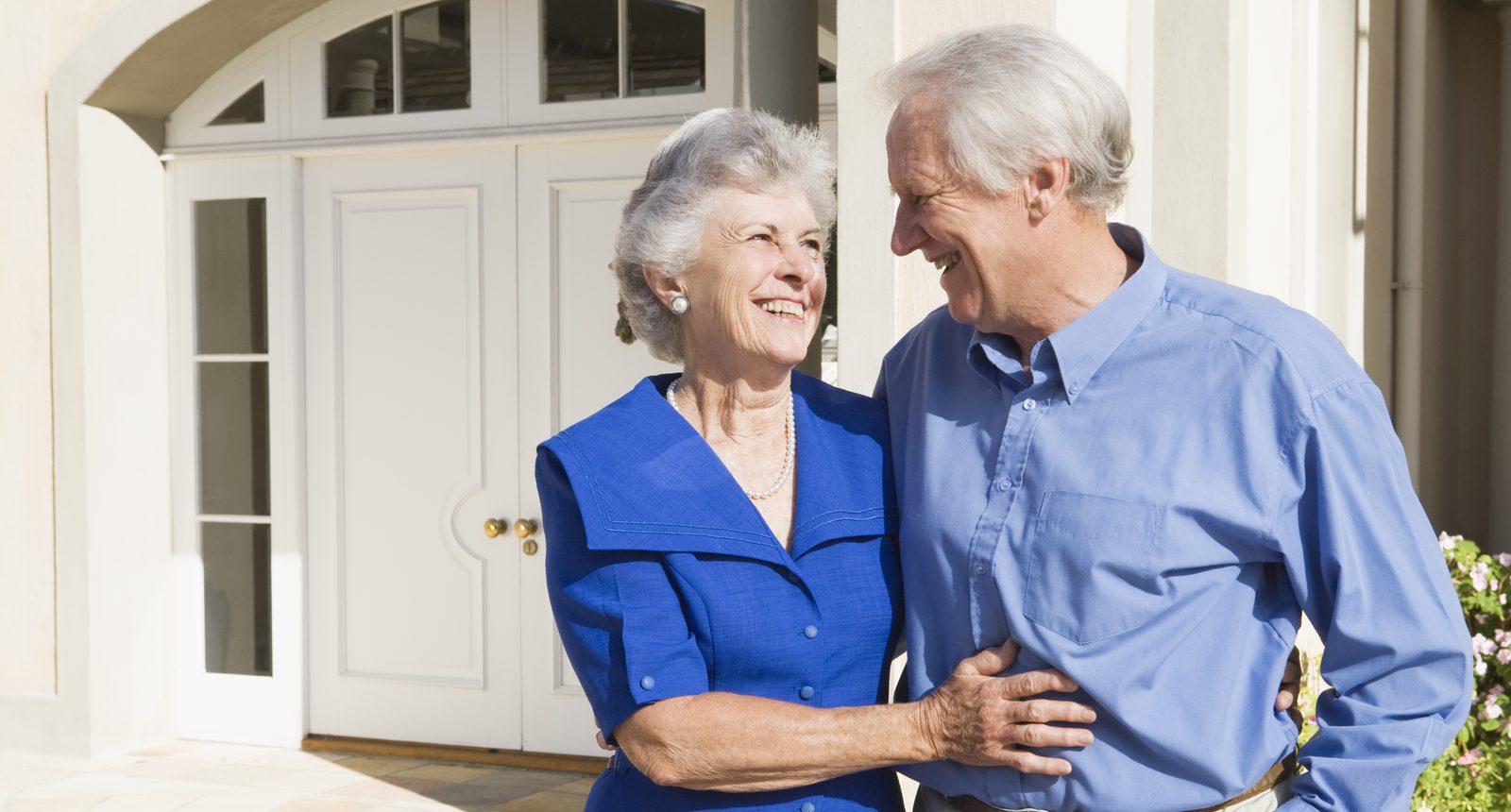 Longtime homeowners in front of the home they are preparing to sell